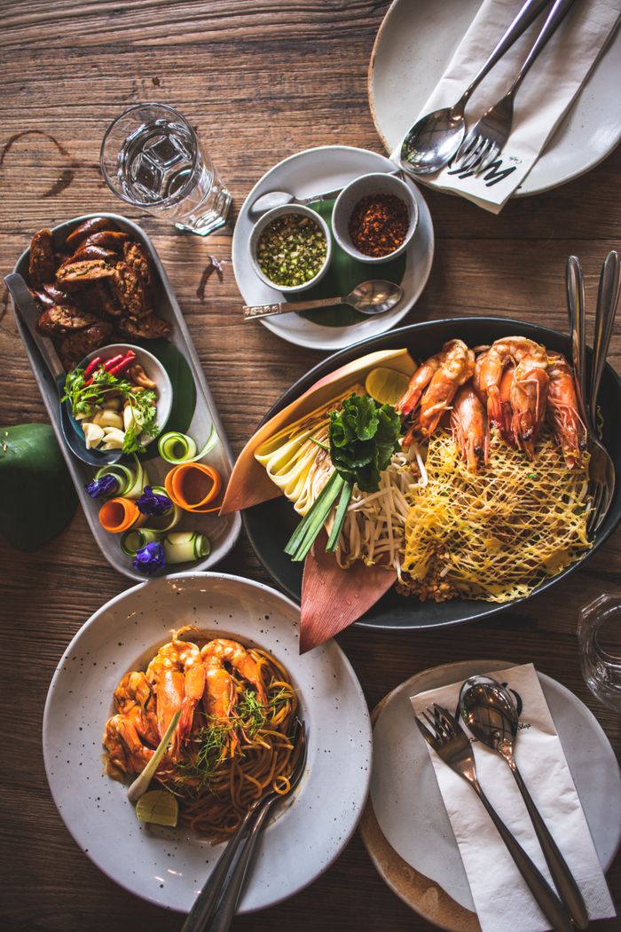 services-02 Delicious spread of Thai seafood with fresh ingredients and vibrant presentation on a wooden table.